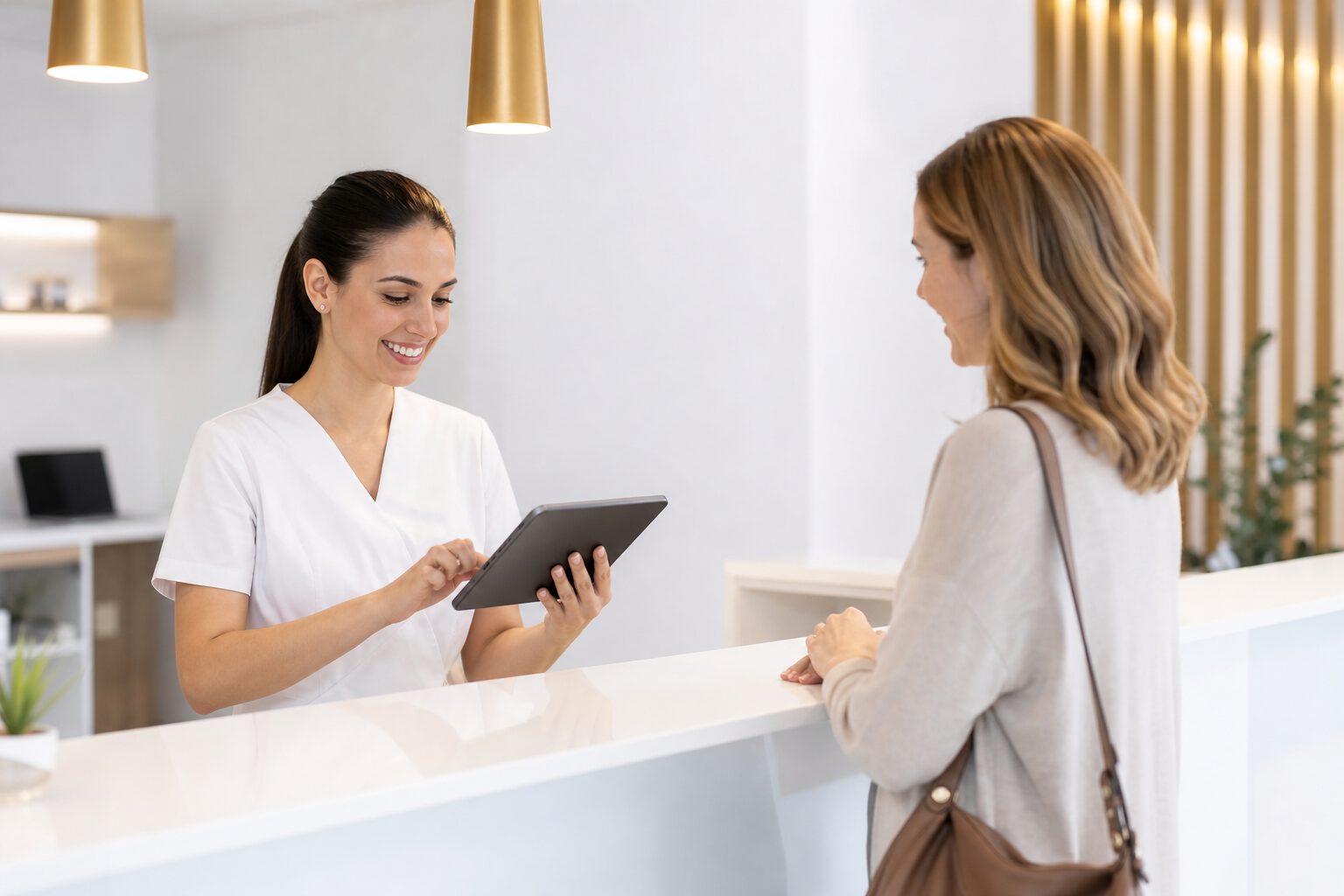 Dental clinic receptionist using Orixdent at a modern front desk